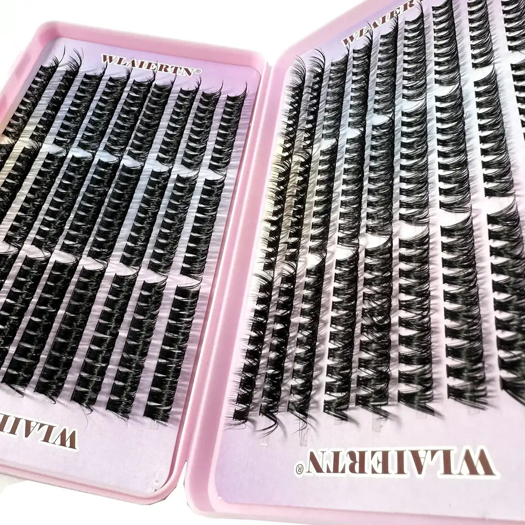 Individual black synthetic false eyelash clusters organized in rows within a pink plastic storage case.