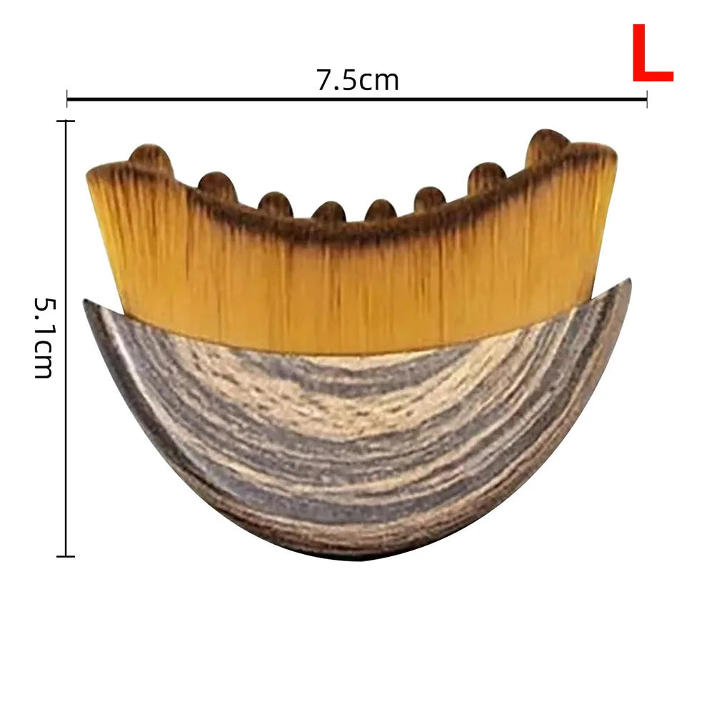 Crescent-shaped facial massage brush with wood-grain handle and soft, dense yellow bristles, 7.5cm wide.