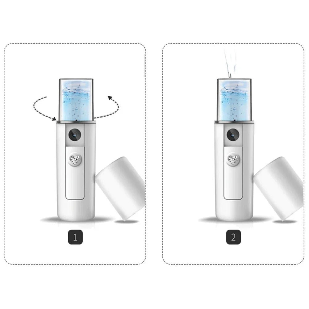 White portable facial mister with a clear water tank, gem-encrusted power button, and misting feature.