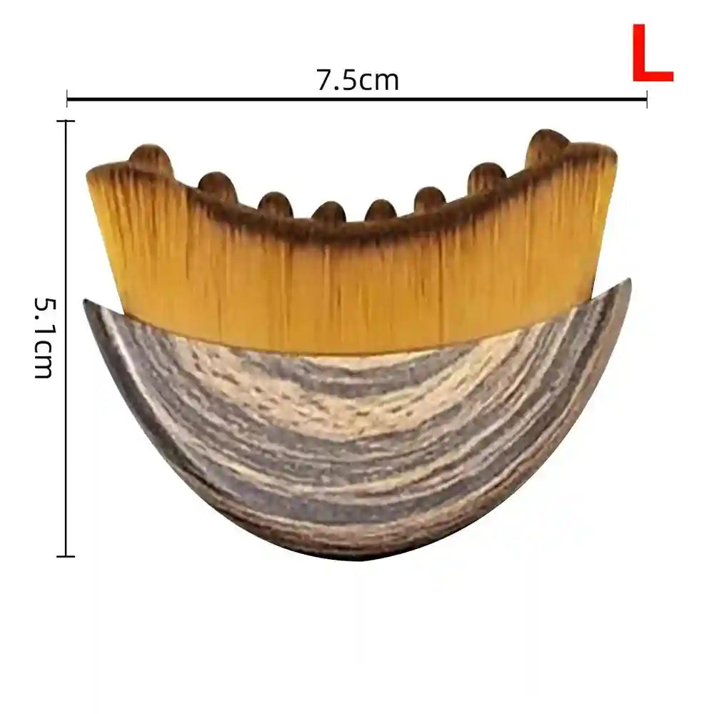 Crescent-shaped facial massage brush with a brown wood-grain base and soft, dense yellow-tipped bristles.