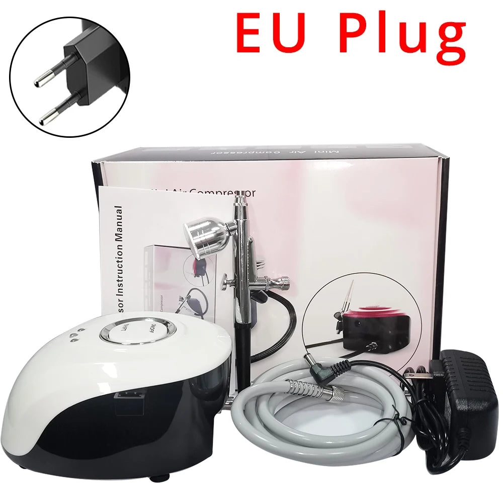 Black and white airbrush compressor kit with silver spray gun, hose, manual, and EU power plug in its retail box.