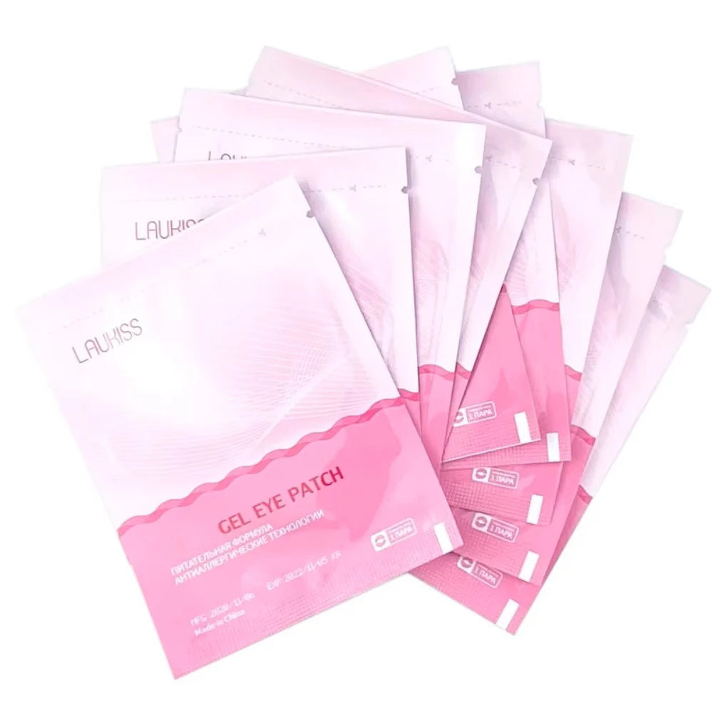 Stack of light pink Laukiss gel eye patches in individual foil packets for eyelash extensions.