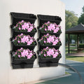 Vertical wall-mounted planter set with six black pockets holding pink flower plants