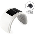 White and black arched LED light therapy mask with internal lights and an AU plug adapter.