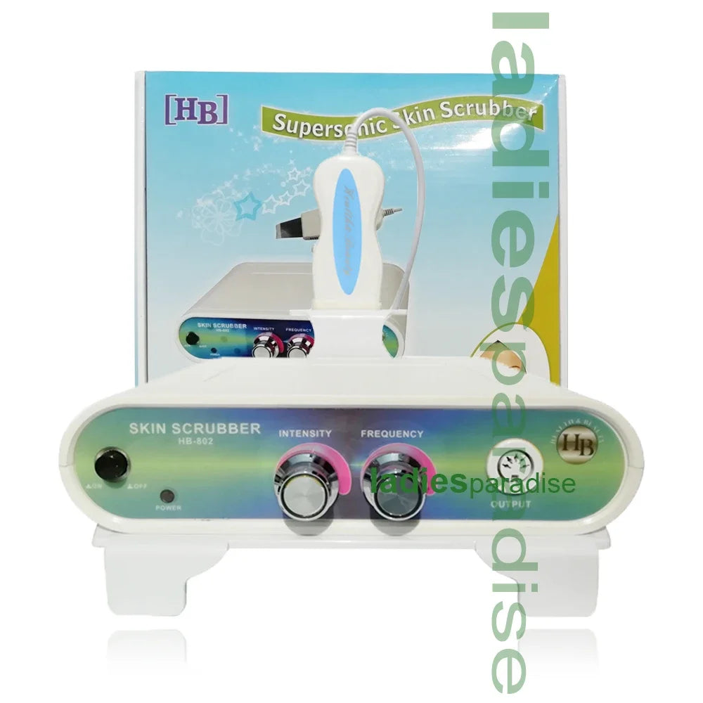 White supersonic skin scrubber machine with handheld spatula, intensity and frequency control knobs, and retail box.