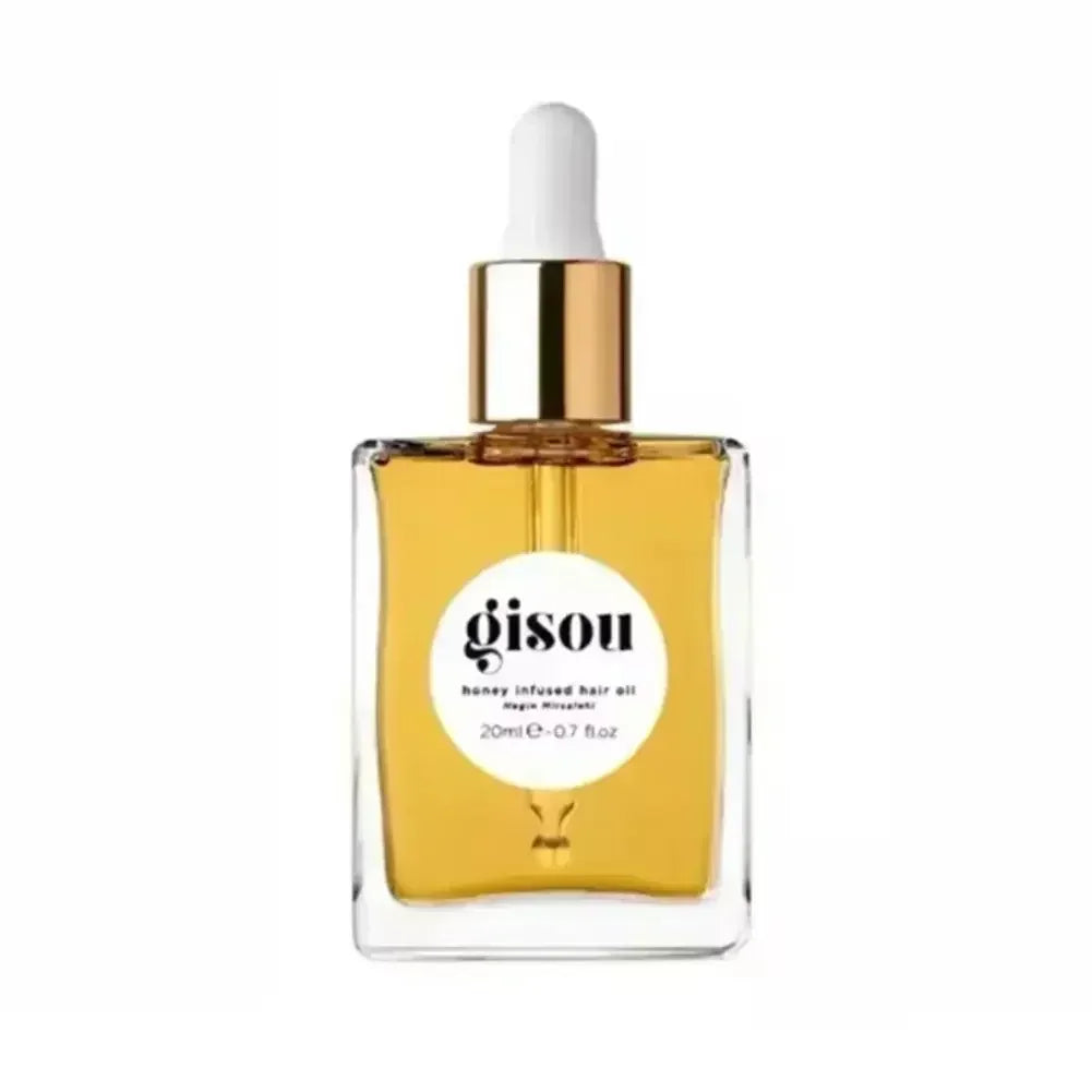 Gisou honey-infused moisturizing lip oil in a clear glass dropper bottle with a gold cap. Golden amber liquid texture.