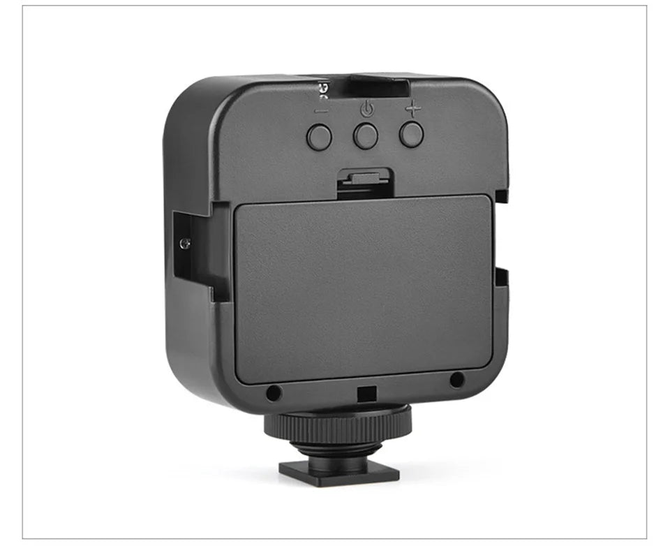Black square LED camera video light with a battery compartment and adjustable brightness buttons, featuring a shoe