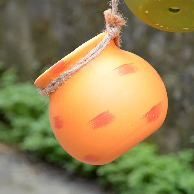 Orange hanging ceramic flowerpot with rope loop and painted speckles