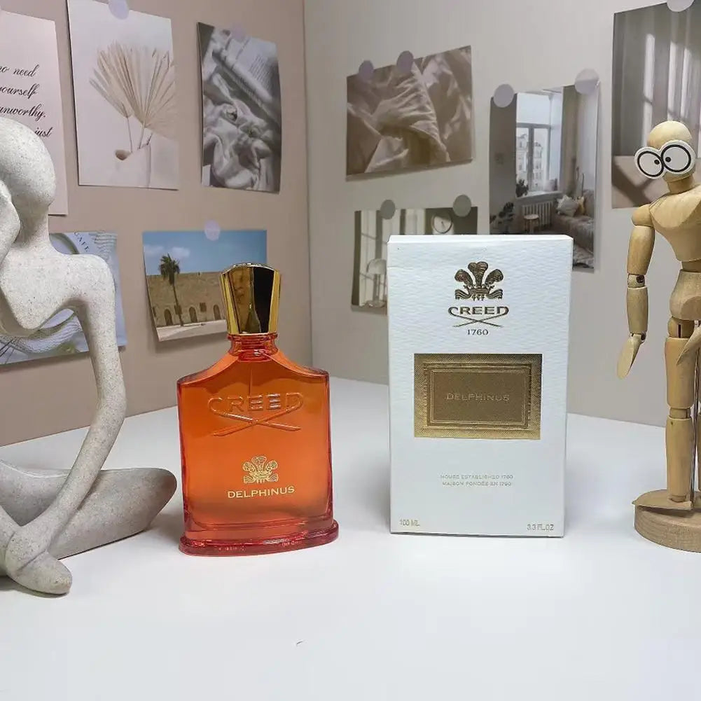 Creed Delphinus EDP perfume in orange glass bottle with gold cap and white gift box, 100ml unisex fragrance spray.