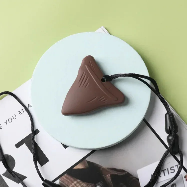 Brown shark tooth silicone baby teething toy pendant on a black cord for teething relief.