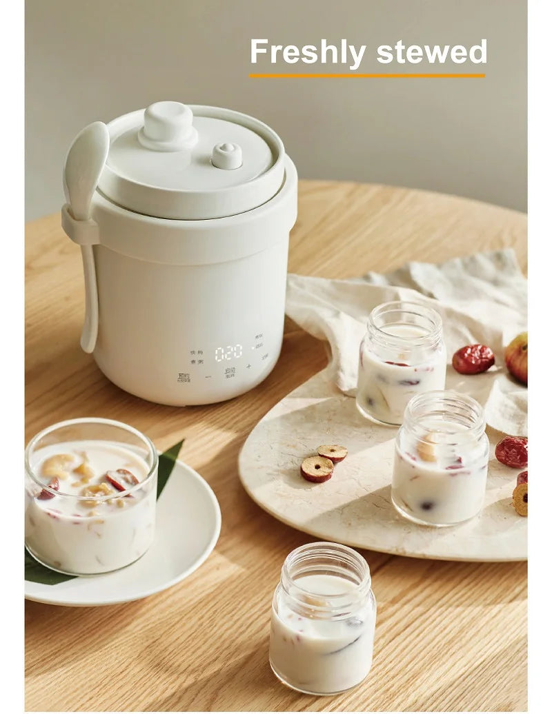 White electric stew pot with carry handle and rounded lid, serving bowls included