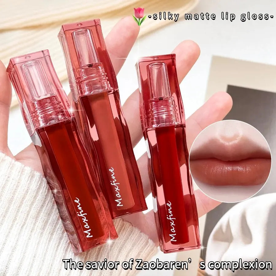 Hand holding three Maxfine silky matte liquid lipsticks in red, showing a moisturizing, pigmented, long-wear lip glaze.