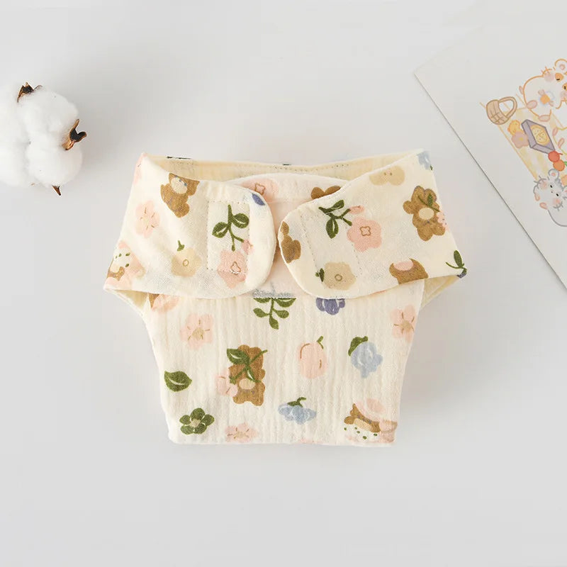Reusable baby care cloth diaper featuring a cream-colored floral and bear print with velcro fasteners.