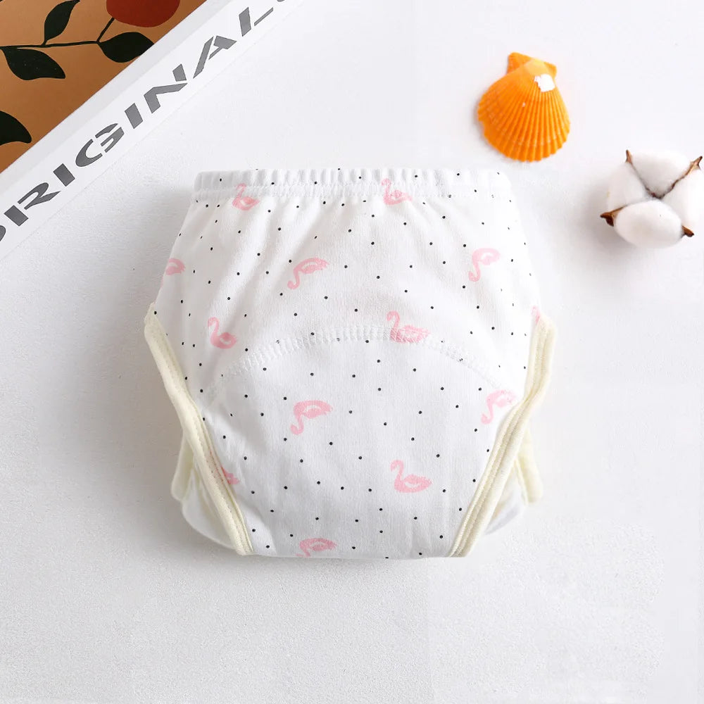 Reusable cotton baby training diaper with white polka dot and pink flamingo pattern on a white background.