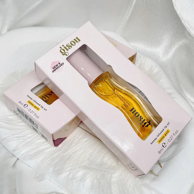 Gisou Honey Infused Lip Oil in gold, a moisturizing, plumping lip gloss treatment in its original pink retail box.