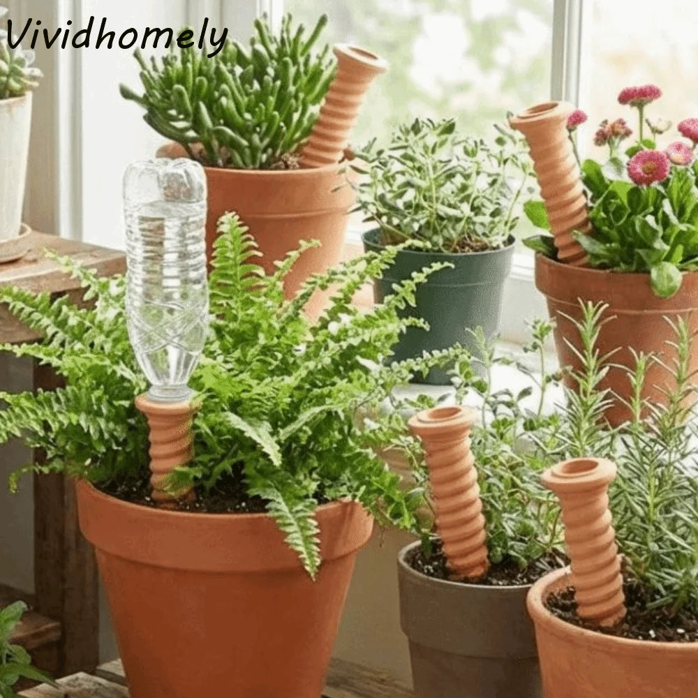 Self-watering terracotta plant irrigation stake with clear water tube, inserted in a pot