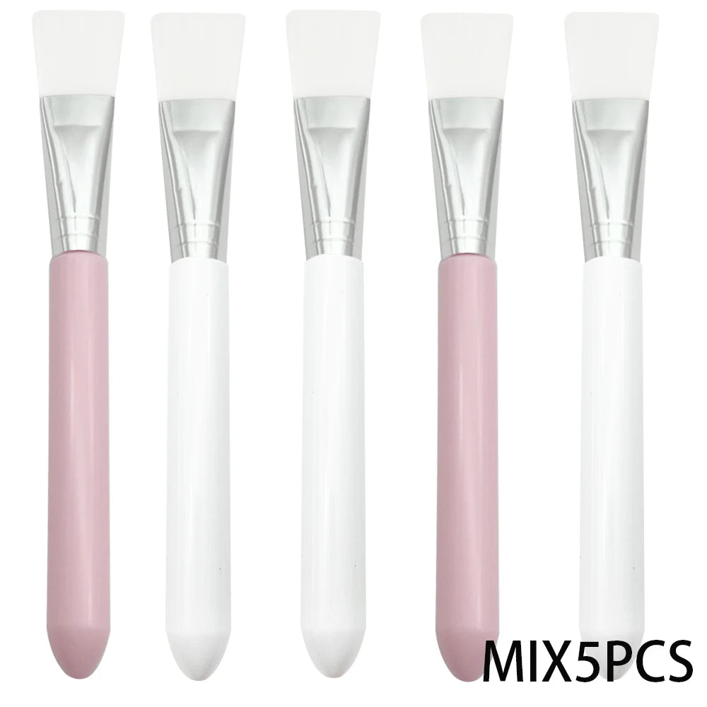 Five face mask brushes with white silicone heads, silver ferrules, and pink or white handles lined up vertically.