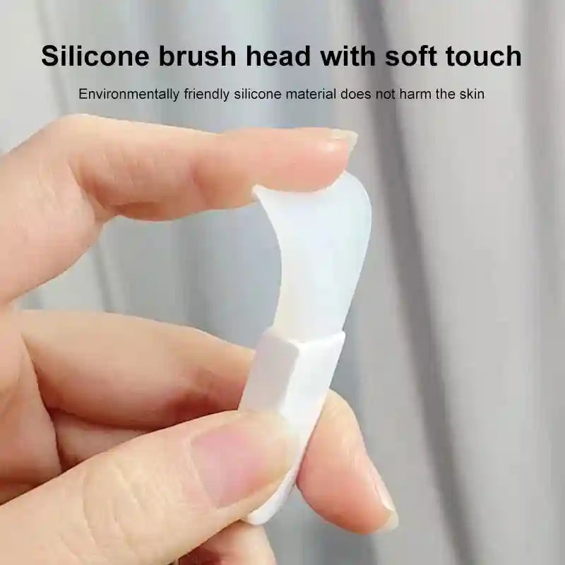 Close-up of a person’s fingers holding a flexible, white silicone facial mask brush with a smooth spatula head.