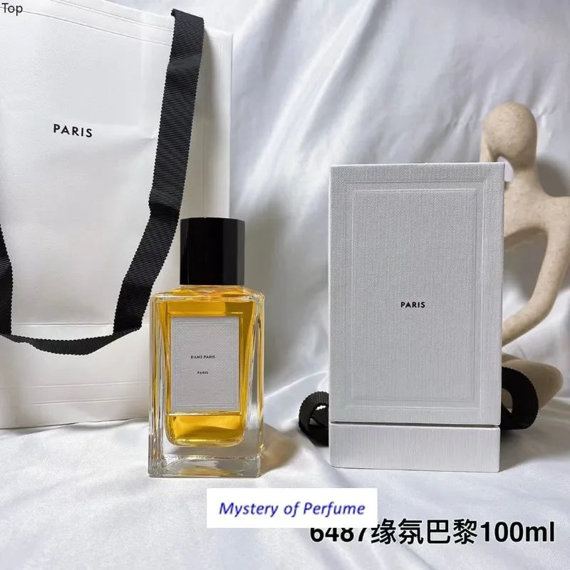 Dans Paris 100ml perfume in a rectangular glass bottle with a black cap, displayed with its white box and paper bag.