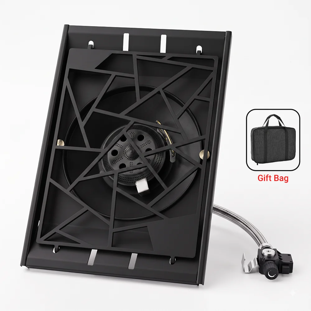 Boxed portable camping stove showing black burner grate and hose connection, with gift bag