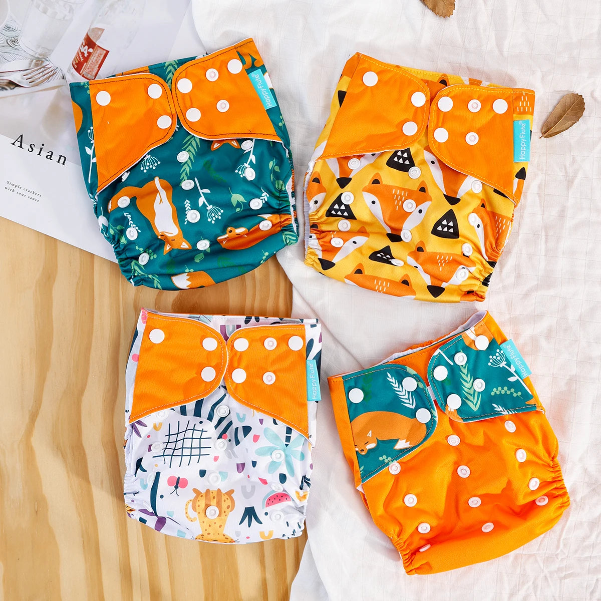 Four Happy Flute adjustable cloth baby diapers with colorful fox and animal prints.
