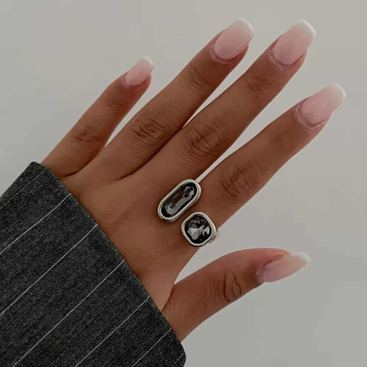 Tidesmit minimalist open ring with two grey acrylic rhinestones in oval and square shapes on a silver-tone metal band.