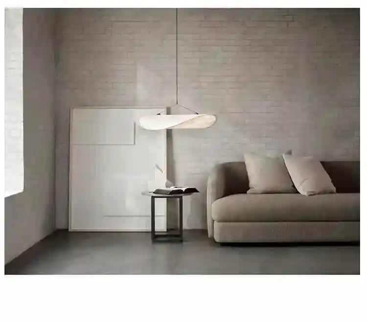 Wavy, white fabric pendant light suspended from the ceiling to provide ambient room lighting.