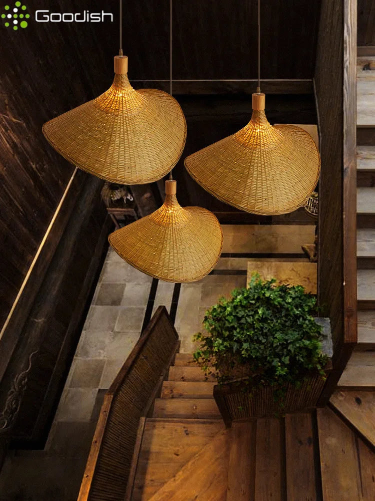 Three large, cone-shaped woven rattan pendant lights hanging in a rustic staircase landing.