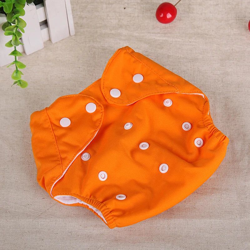 Bright orange reusable baby cloth diaper with adjustable snap fasteners for a customizable, eco-friendly fit.