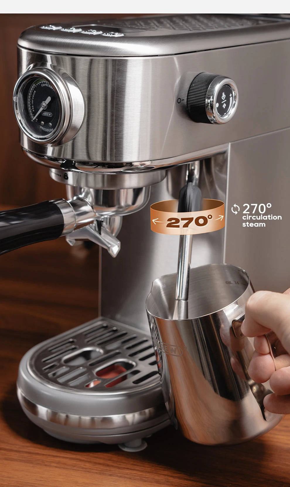 Stainless steel espresso machine with 270-degree swivel steam wand and pressure gauge frothing milk in a metal pitcher.