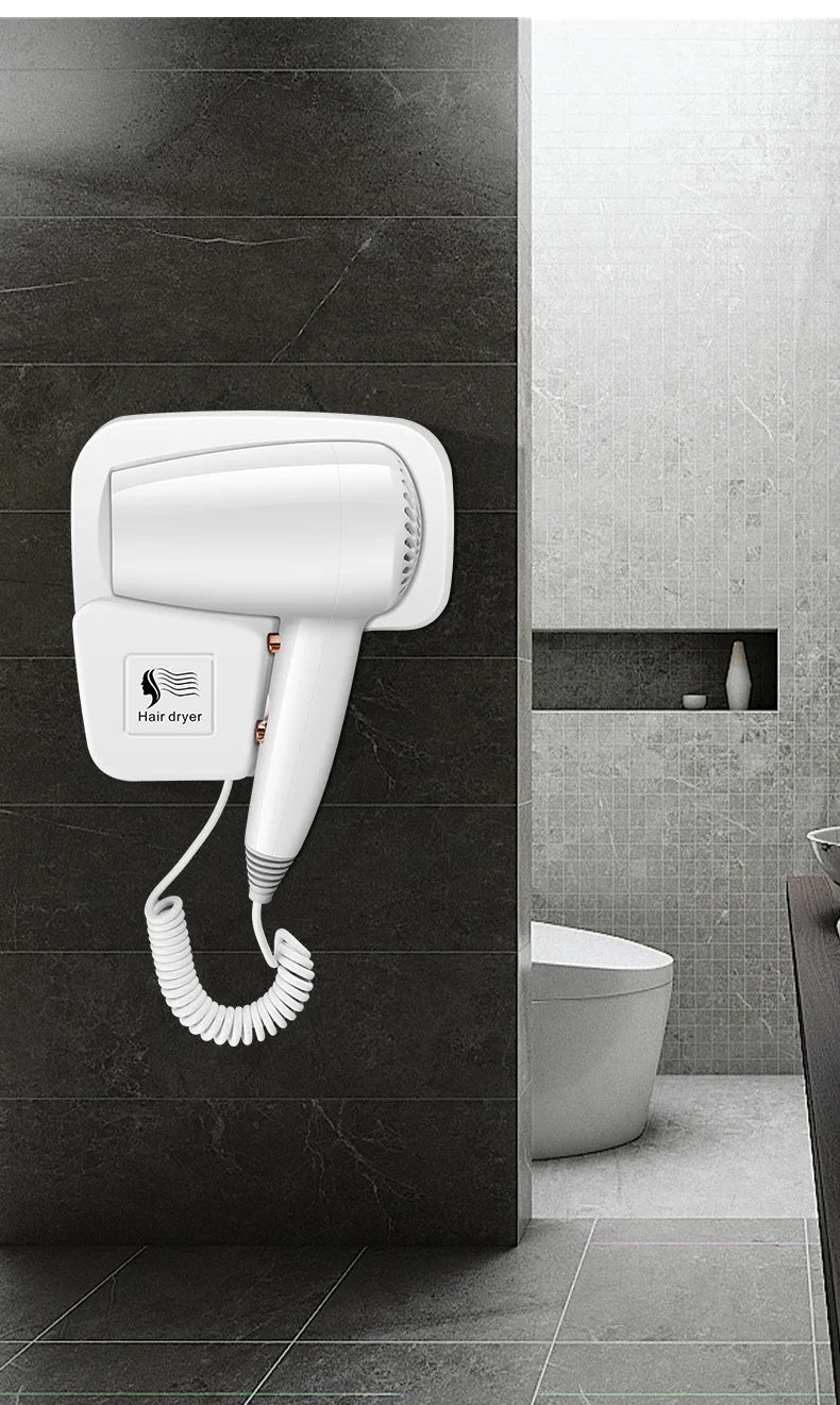 White wall-mounted hair dryer with coiled cord for home or hotel bathrooms. Compact, non-perforated design for vanity.