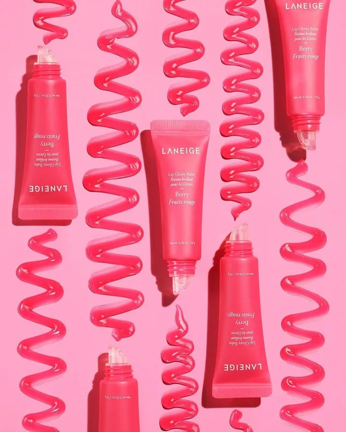 Laneige Berry Lip Glowy Balm tubes with glossy pink texture swirls on a matching pink background.