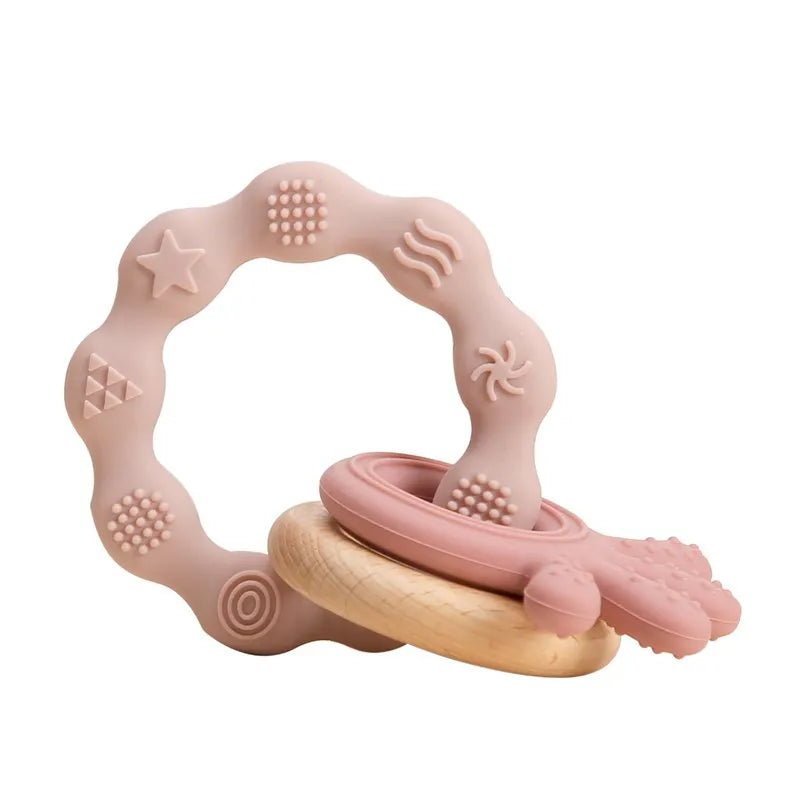 Pink silicone and wood baby teething ring toy for sensory relief and gum soothing.