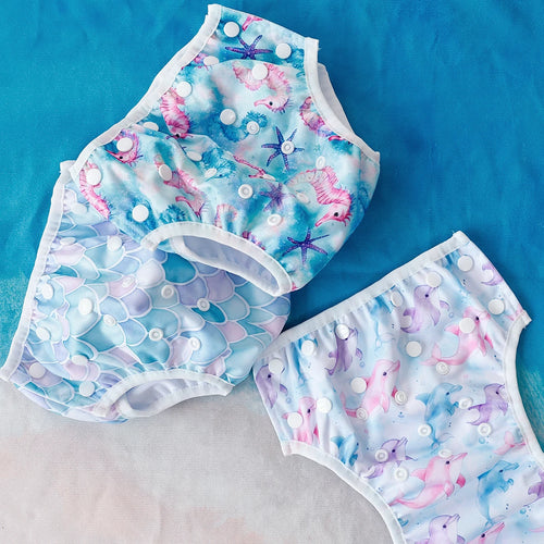 Adjustable reusable baby swim diapers in ocean-themed seahorse, mermaid scale, and dolphin prints.