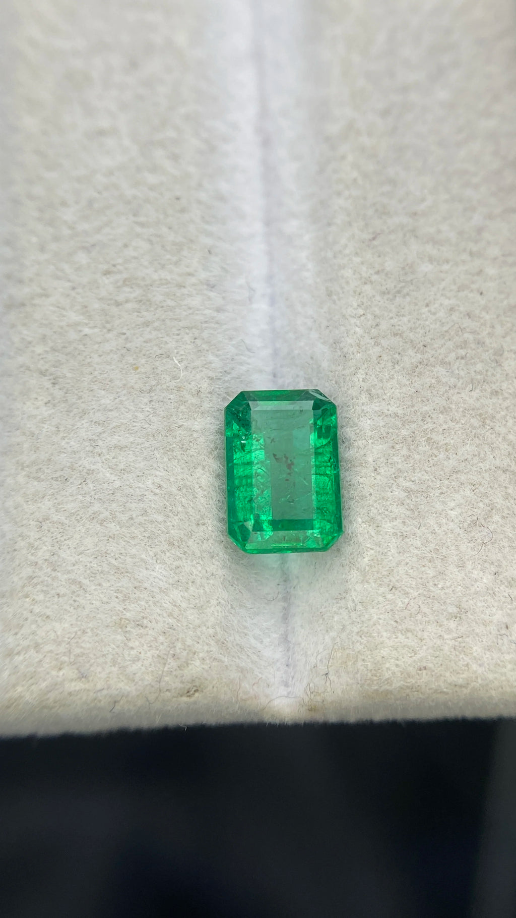 Green emerald-cut rectangular gemstone with visible facets, loose for making jewelry