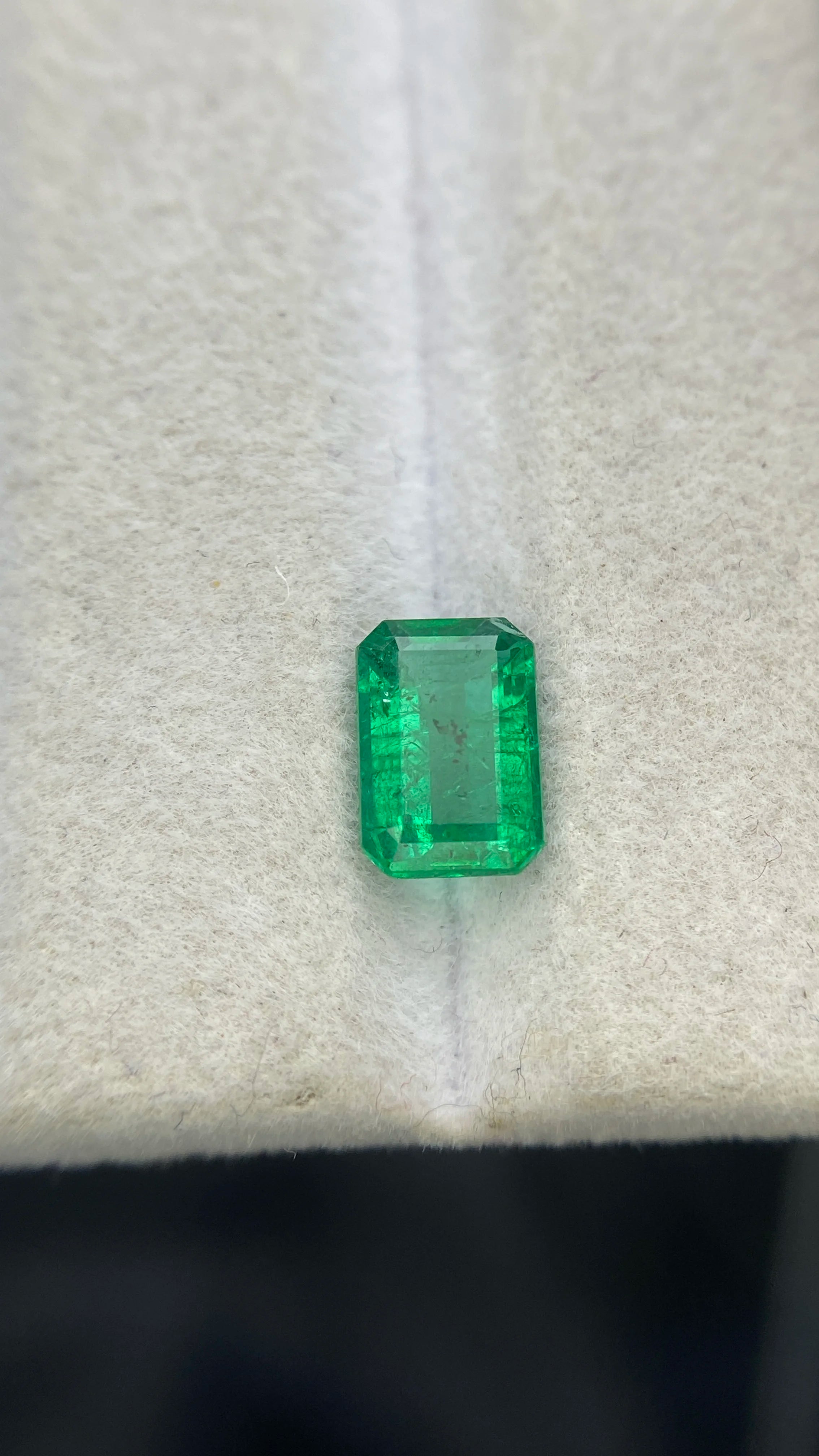 Green emerald-cut rectangular gemstone with visible facets, loose for making jewelry