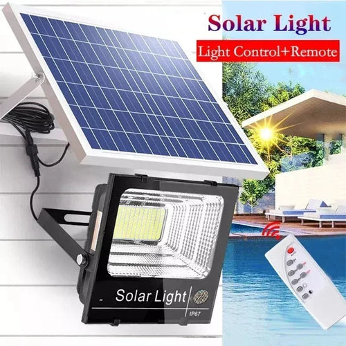 Black LED solar flood light with blue solar panel and remote control for outdoor security.