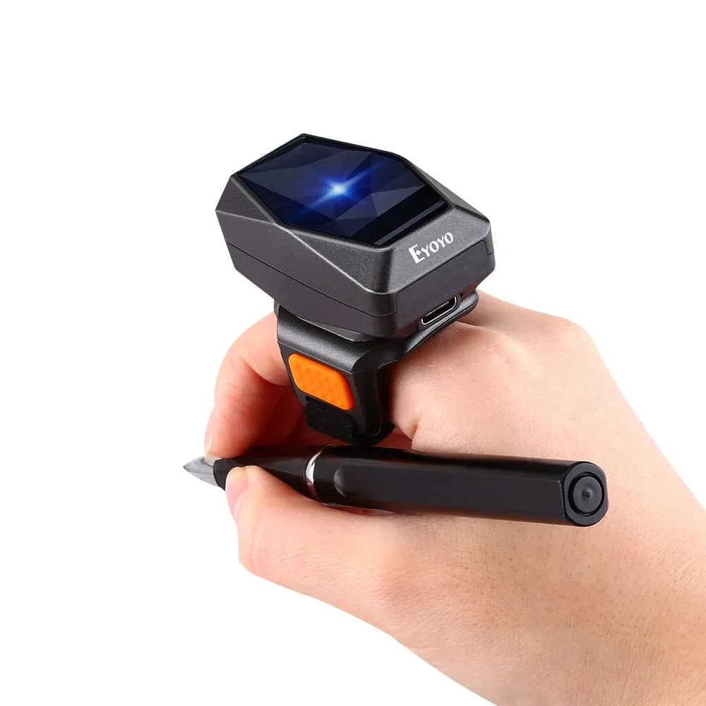Wearable ring barcode scanner, black housing with orange trigger, worn on a finger.
