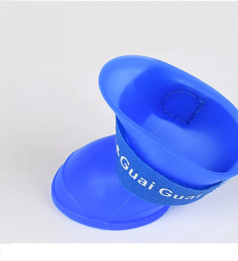 Blue waterproof non-slip dog rain boots with secure strap for paw protection during outdoor walks.