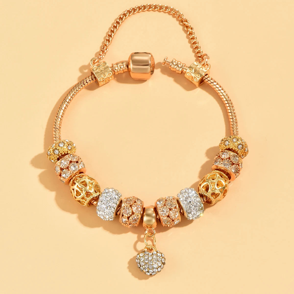 Tidesmit gold-tone snake chain charm bracelet with crystal-encrusted beads and a sparkling heart pendant.