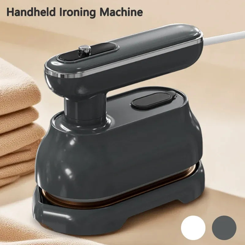 Handheld ironing machine in dark gray resting on a base next to folded towels for quick garment steaming.
