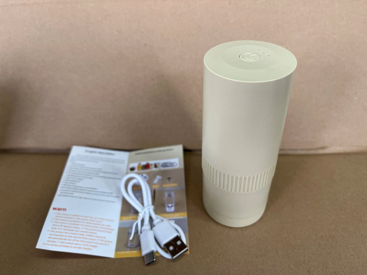 White cylindrical vacuum sealer standing with USB cable and instruction papers