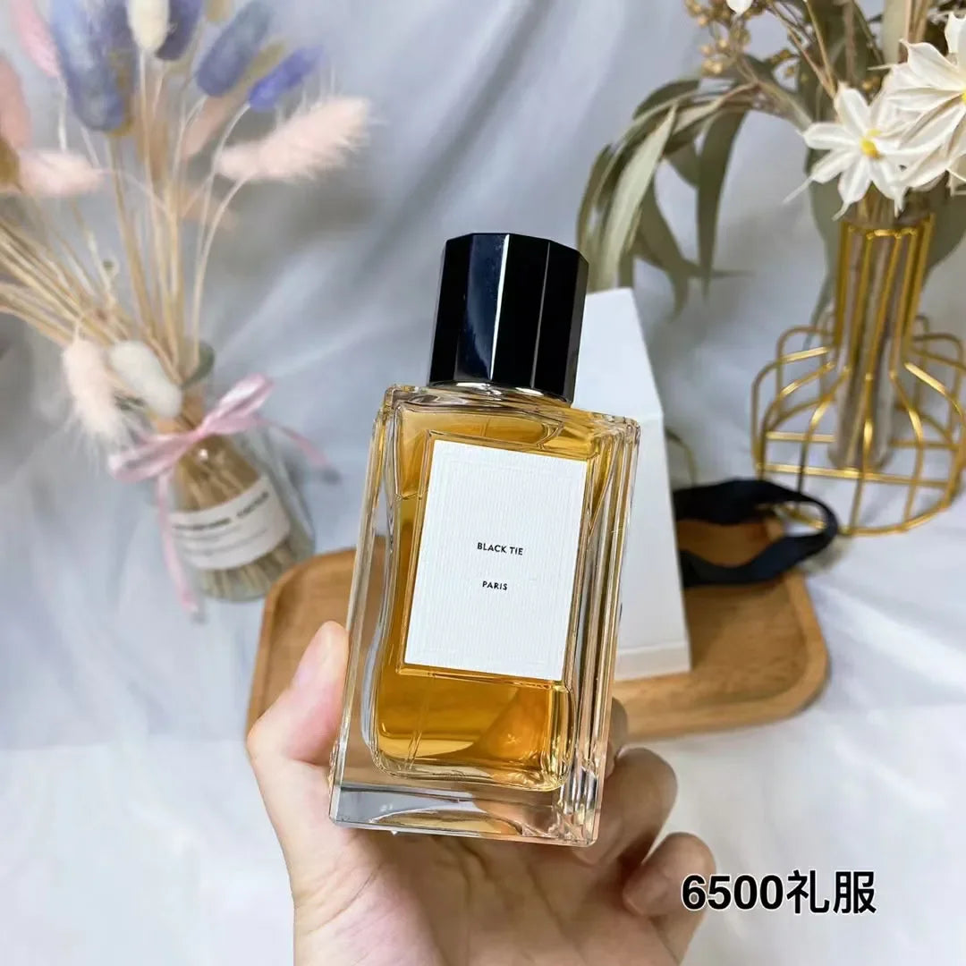 Black Tie Paris perfume in a rectangular glass bottle with a black cap, filled with amber-colored fragrance.