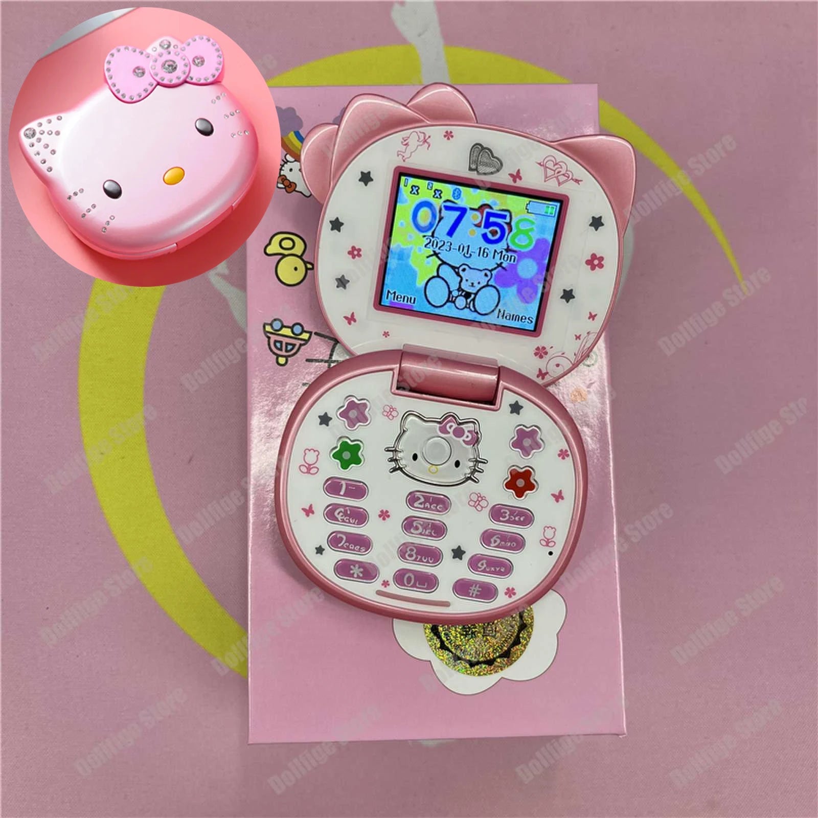 Pink Hello Kitty flip phone with rhinestone bow, color screen, and character-themed buttons on a matching gift box.