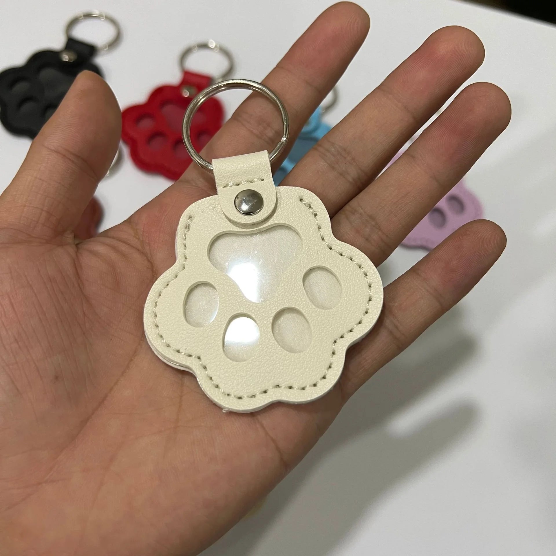 White leather cat paw keychain for pet hair storage, a portable multifunctional bag pendant for cat lovers.