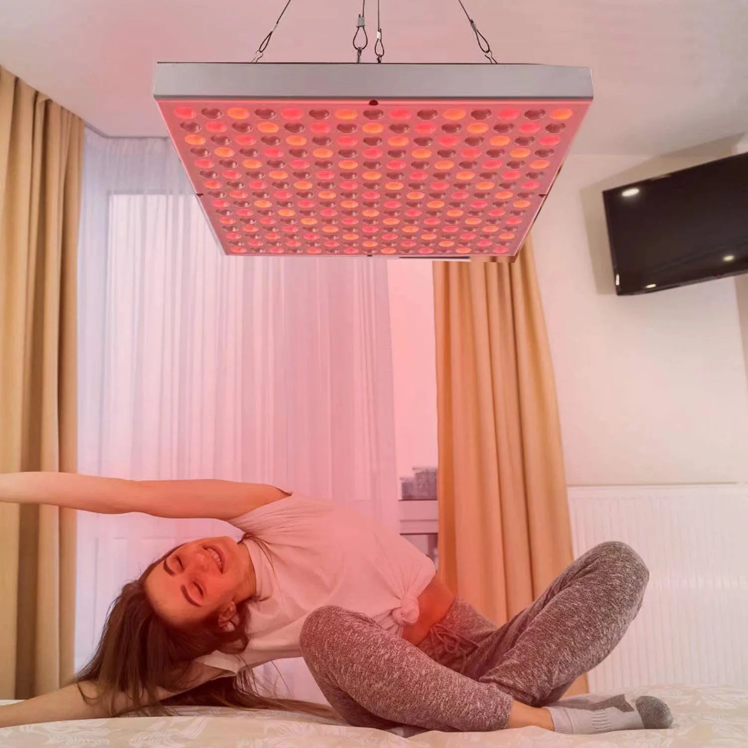 45W red light therapy panel with 660nm and 850nm LED wavelengths hanging above a woman stretching on a bed.