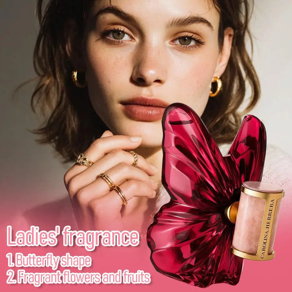 Butterfly-shaped perfume bottle in deep red glass with a cylindrical gold and light pink base.