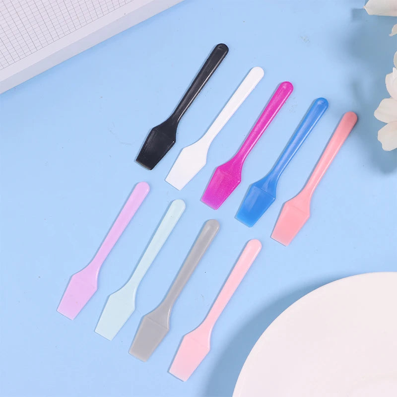 A set of small, colorful plastic cosmetic spatulas for applying skincare masks and creams.