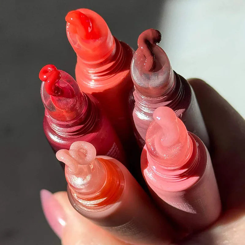 Summer Fridays moisturizing lip balm set with smooth, glossy, transparent textures in diverse shades in soft tubes.