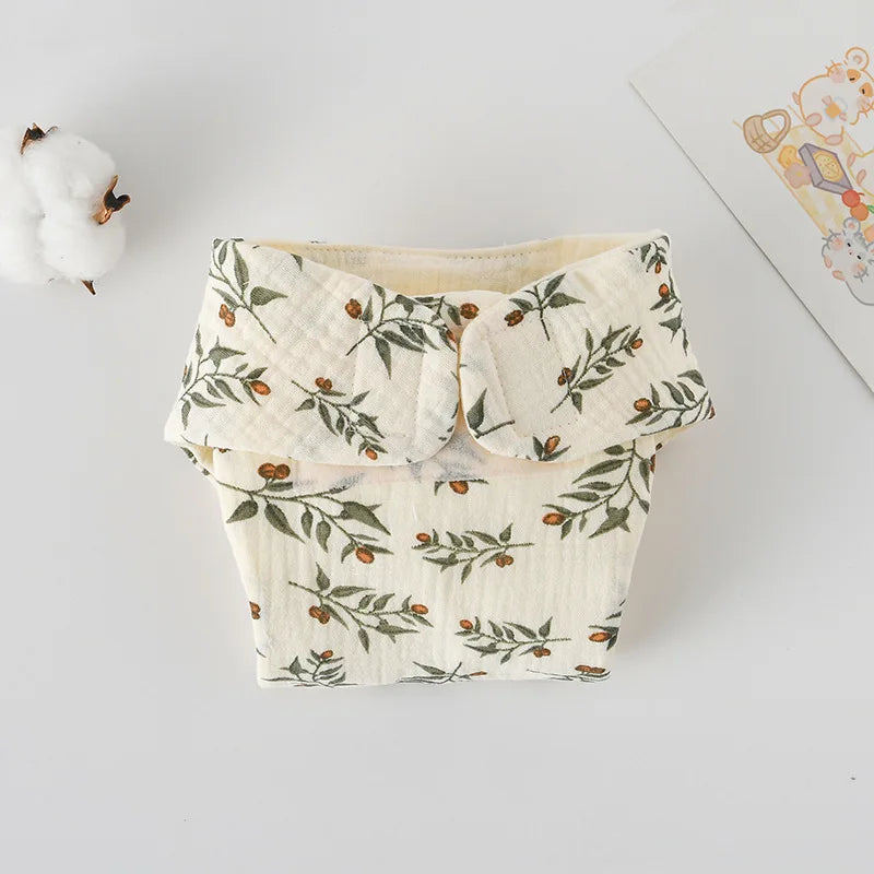 Reusable cloth baby diaper with cream leaf and berry print design. Soft muslin baby care essential.